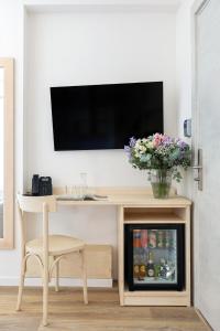 a living room with a television and a table with a refrigerator at Hotel Week End in Porto Santo Stefano +92 photos