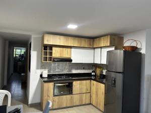 a kitchen with wooden cabinets and a stainless steel refrigerator at Apartamento Cocorna Aventura in Cocorná +20 photos