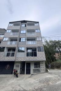 a motorcycle parked in front of a tall building at Apartamento Cocorna Aventura in Cocorná