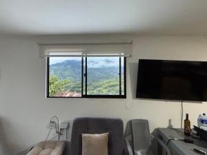 a window in a room with a couch and a television at Apartamento Cocorna Aventura in Cocorná