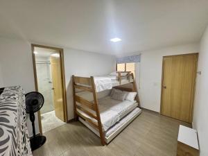 a bedroom with two bunk beds and a bathroom at Apartamento Cocorna Aventura in Cocorná