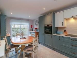 a kitchen with a wooden table and a dining room at Spring Cottage in Duns