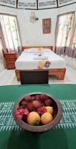 a room with a bed and a bowl of fruit at Talanoa Fales Accommodation in Apia