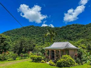 a small house in front of a mountain at Talanoa Fales Accommodation in Apia