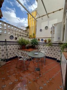 a patio with a table and chairs on a balcony at Casa Turistica Termas aparcamiento y desayuno incluido in Mérida
