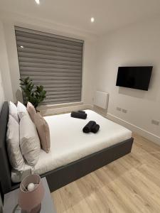 a bedroom with a bed with a flat screen tv at 37 Syward Place in Chertsey