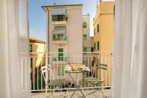 a balcony with a table and chairs and a building at Hotel Week End in Porto Santo Stefano