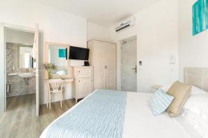 a white bedroom with a bed and a desk at Hotel Week End in Porto Santo Stefano