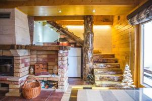 a kitchen with a stone fireplace in a house at Holiday Home Floris in Kopaonik