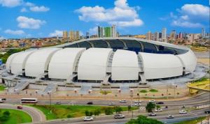 a large white stadium with a city in the background at Espaço do acalanto- Quarto em apartamento compartilhado in Natal