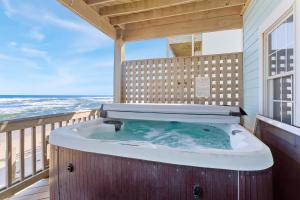 a jacuzzi tub on a balcony with the ocean at 8046 - Sun Runner in Rodanthe