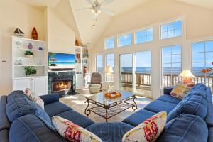 a living room with a blue couch and a fireplace at 8046 - Sun Runner in Rodanthe