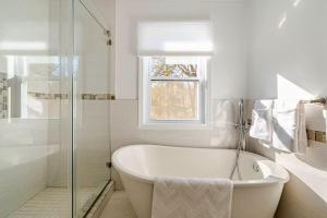 a white bathroom with a tub and a window at Norwalk Retreat in Norwalk +28 photos