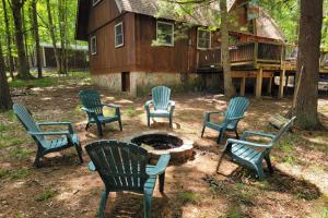 a group of chairs around a fire pit in front of a house at Grossis Geschenk by Railey Vacations in Swanton