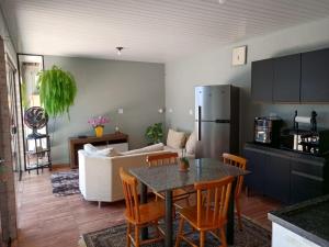a kitchen and living room with a table and a refrigerator at Studio Carimã Foz in Foz do Iguaçu