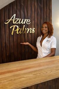 a woman standing next to a table with a sign at Azure palms hideaway in Kingston