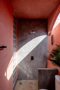 a bathroom with a concrete wall with a staircase at Amplitude Coliving in Brisas de Zicatela +61 photos