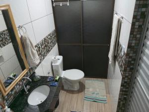 a bathroom with a toilet and a sink and a mirror at Studio Carimã Foz in Foz do Iguaçu +10 photos