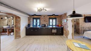 a kitchen with black cabinets and a brick wall at Apartment 22 - zentrumsnah - Parkplatz in Coburg