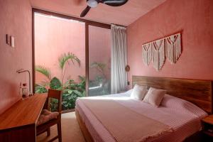 a bedroom with a bed and a large window at Amplitude Coliving in Brisas de Zicatela