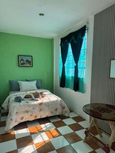 a bedroom with a bed and a table and a window at Nawal Hostel in Santa Cruz La Laguna +36 photos