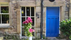a blue door and flowers in front of a building at Ground floor, Very central, 2 Bed - Cobbles Apartment in Buxton