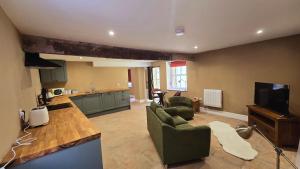 a living room with a couch and a tv in it at Ground floor, Very central, 2 Bed - Cobbles Apartment in Buxton