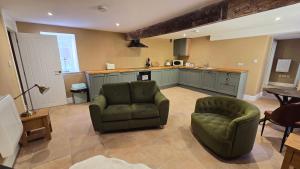a living room with a couch and a chair and a kitchen at Ground floor, Very central, 2 Bed - Cobbles Apartment in Buxton +6 photos
