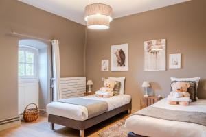 a bedroom with two beds with teddy bears on them at Hotel Ô Château in Hayange