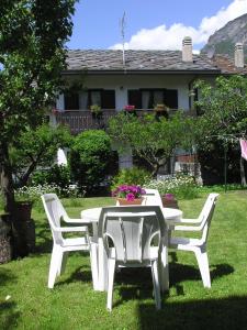 un tavolo bianco e sedie in un cortile di B&B Au Petit Bonheur a Saint Vincent