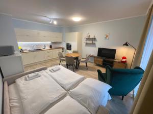 a bedroom with a bed and a table and a kitchen at Kora Apartments in Prague +109 photos