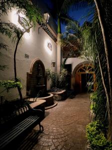 a courtyard with a bench in a building with trees at Hotel Boutique in Querétaro