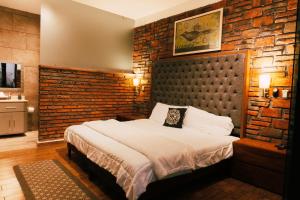 a bedroom with a bed and a brick wall at Hotel Boutique in Querétaro