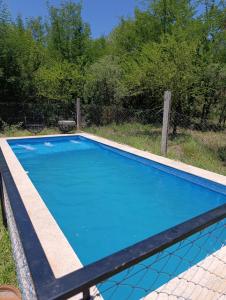 a large blue swimming pool with a fence at La Morada de sus Sueños Caeiro in Bialet Massé