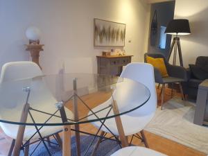 a living room with a glass table and chairs at Gîte Les Fourmilières in Ligny-le-Ribault