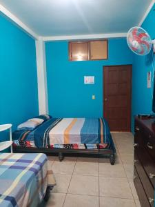 a bedroom with blue walls and a bed in it at Hospedaje Piquero in Puerto Baquerizo Moreno