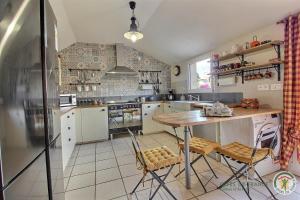 a kitchen with a table and some chairs in it at Le gite riad de kerity in Paimpol