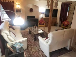 a living room with two white chairs and a table at Le gite riad de kerity in Paimpol