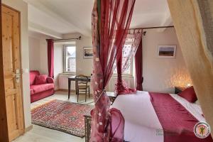 a bedroom with a canopy bed with red curtains at Le gite riad de kerity in Paimpol