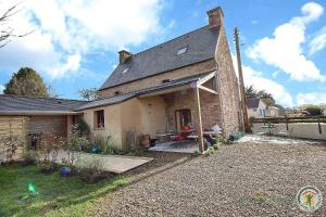 an old brick house with a picnic table in front of it at Le gite riad de kerity in Paimpol