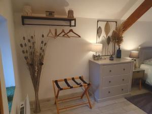 a bedroom with a bed and a chair and a dresser at Gîte Les Fourmilières in Ligny-le-Ribault +25 photos