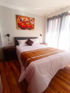 a bedroom with a large white bed in front of a window at Residencial SKD in Puno