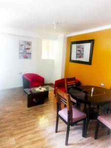 a living room with a table and red chairs at Residencial SKD in Puno