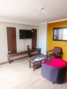 a living room with a tv and a couch and a table at Residencial SKD in Puno
