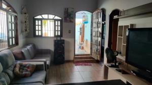 a living room with a couch and a flat screen tv at Recanto do mar in Caraguatatuba