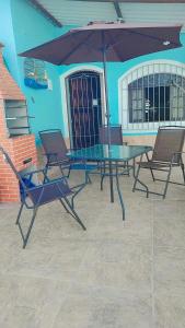 a table and chairs with an umbrella on a patio at Recanto do mar in Caraguatatuba