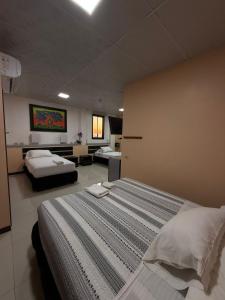 a large bedroom with two beds and a couch at Hotel Los Algarrobos in Puerto Baquerizo Moreno +34 photos
