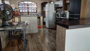 a kitchen with a table and a refrigerator at Recanto do mar in Caraguatatuba