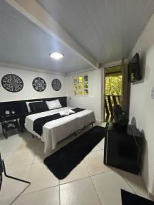 a bedroom with a bed and a television in it at Hari Eco Pousada in Brumadinho
