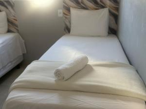 a towel on a bed in a hotel room at Amazon LOFT 08 in Sorriso